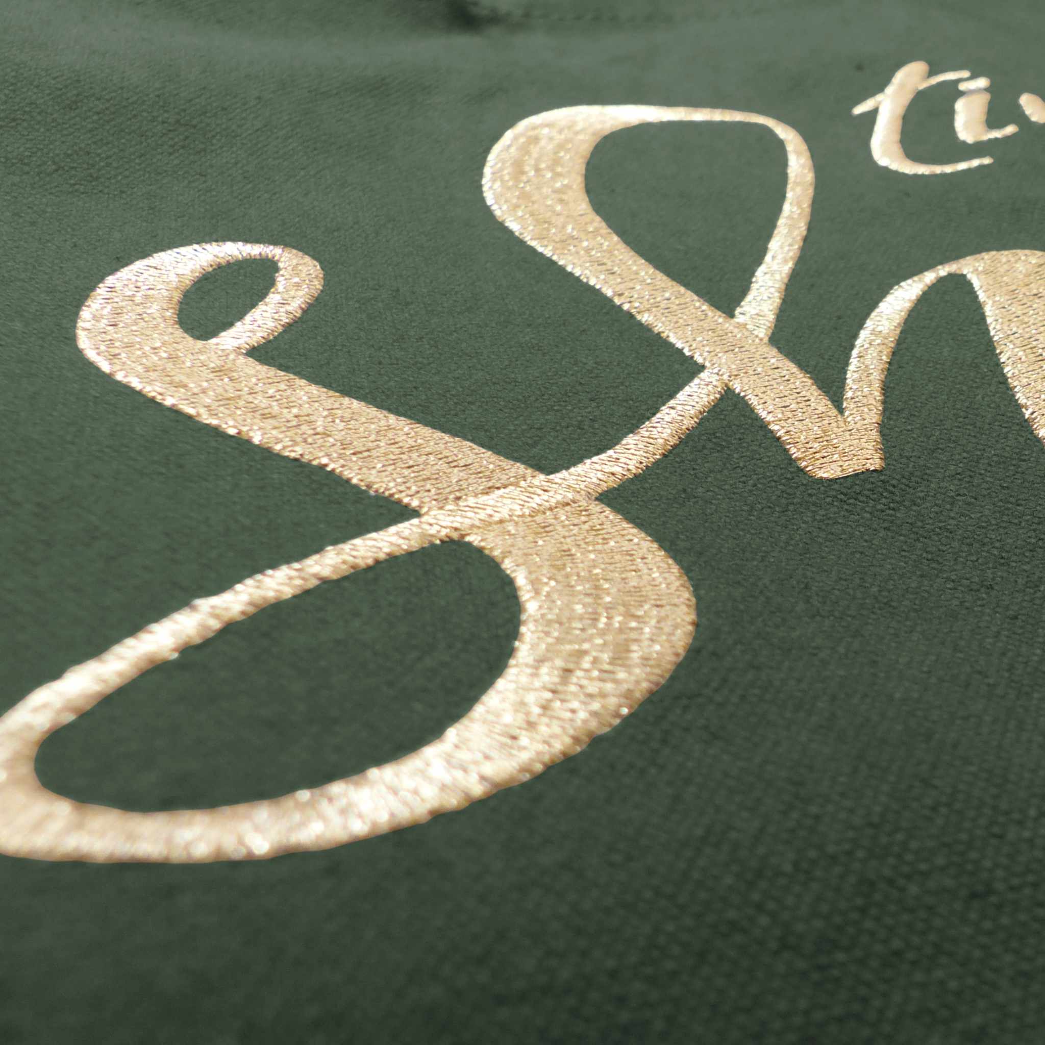 Nahaufnahme einer robusten XL GOTS-Tote Bag aus stabilem Canvas (100% Biobaumwolle), mit Fokus auf die edel schimmernde Stickerei in gold-metallic Schriftzug Time to shine. Farbton Oliv