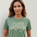 Spirituelles Baumwoll T-Shirt mit Affirmation für Damen, TShirt Farbe hellgrün. Die Affirmation ist eine Stickerei in Gold-Metallic, Schriftzug: I'm creating my own destiny