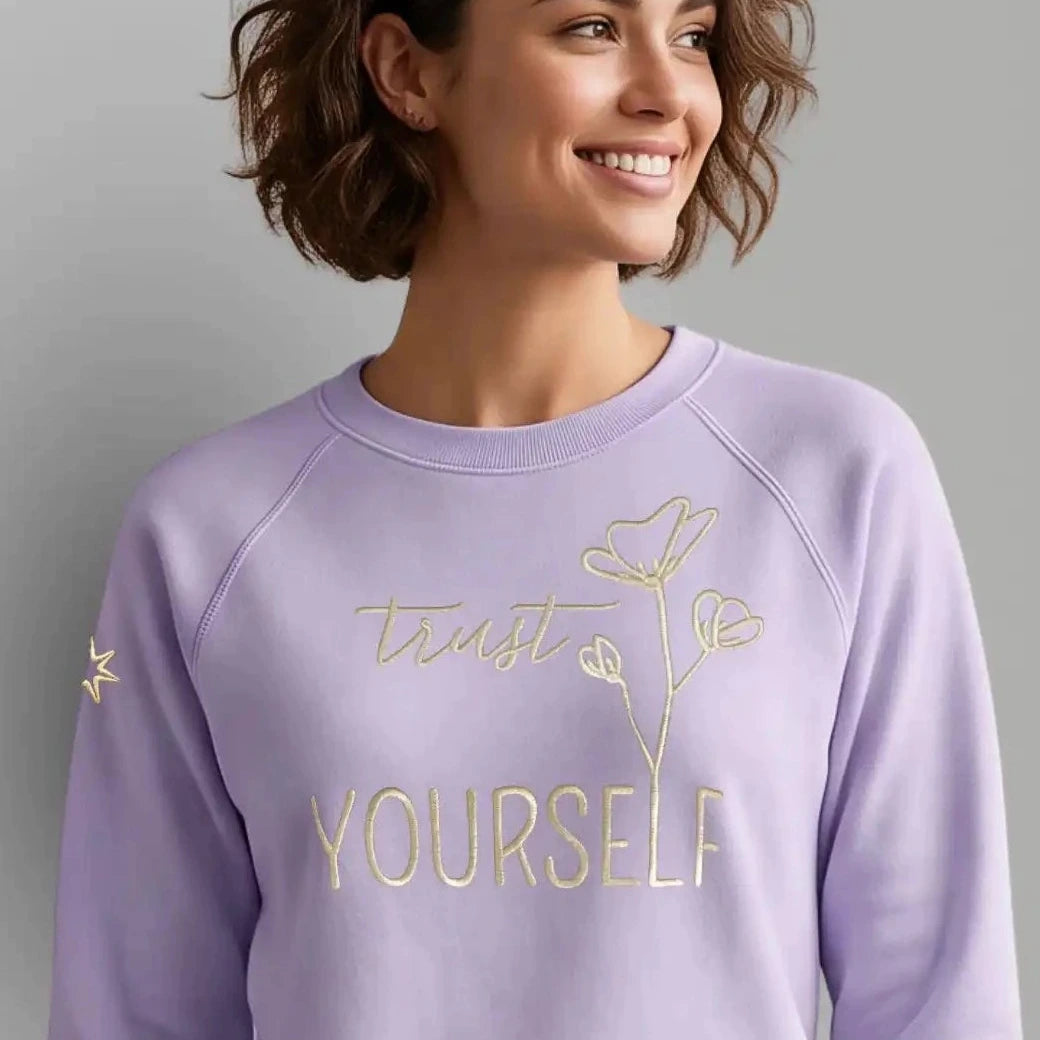 Spiritueller Damen Statement Sweater mit Affirmation. Die Affirmation ist eine goldene Stickerei mit Schriftzug 'Trust yourself' mit floralem Design.