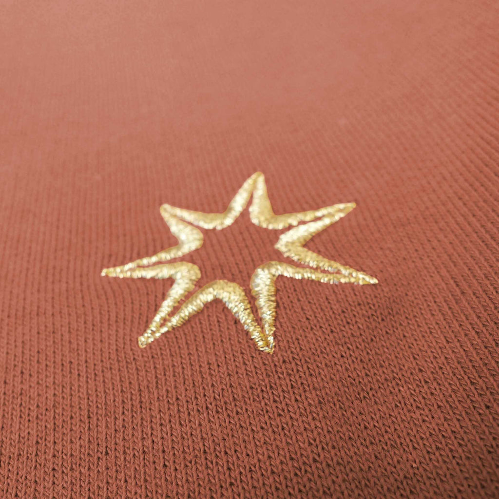 Nahaufnahme der Sterne Stickerei (siebenzackiger Stern) am Ärmel eines nachhaltigen Damen GOTS Sweatshirts aus 100% Bio Baumwolle im Farbton terracotta.