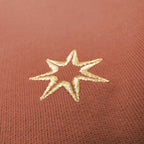 Nahaufnahme der Sterne Stickerei (siebenzackiger Stern) am Ärmel eines nachhaltigen Damen GOTS Sweatshirts aus 100% Bio Baumwolle im Farbton terracotta.