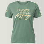 Grünes Bio-T-Shirt für Damen aus 100% zertifizierter Biobaumwolle in milden Grünton, große edle Frontstickerei in gold-metallic I'm creating my own destiny, Logo-Stickerei am rechten Ärmel: siebenzackiger Stern